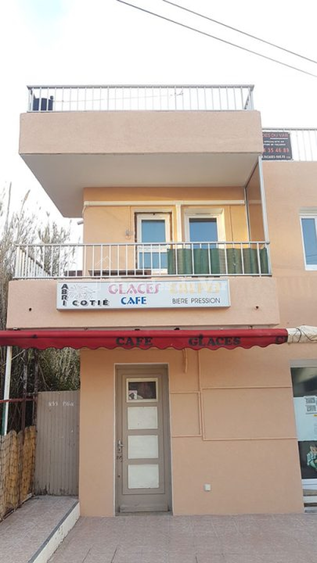 Façades du Var, bâtiment avec balcon et enseigne de café et crêpes.